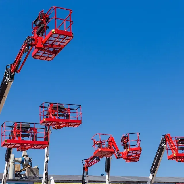 Una fila de elevadores de cubo rojos contra un cielo azul