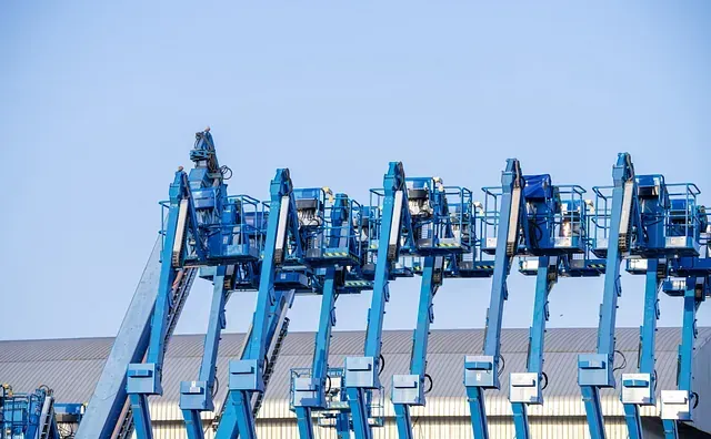 Una fila de elevadores aéreos azules están alineados frente a un edificio.