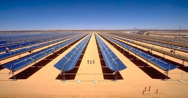 Una fila de paneles solares en el desierto con un cielo azul de fondo.