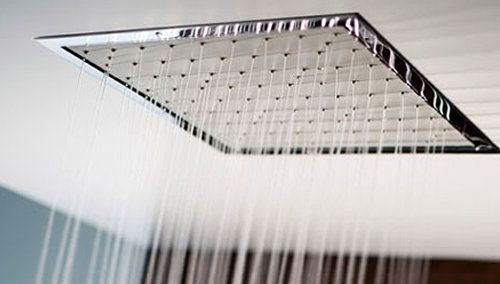 Un primer plano de un cabezal de ducha del que sale agua.