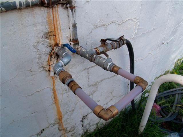 Una manguera está conectada a un grifo con una válvula azul.