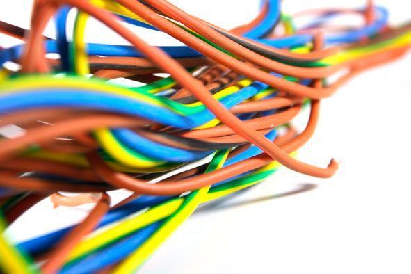 Un montón de cables de colores sobre una superficie blanca