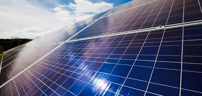 Un primer plano de un panel solar con un cielo azul de fondo.