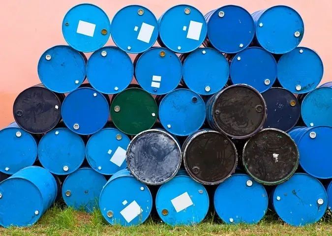 Una pila de barriles azules y negros están apilados uno encima del otro.