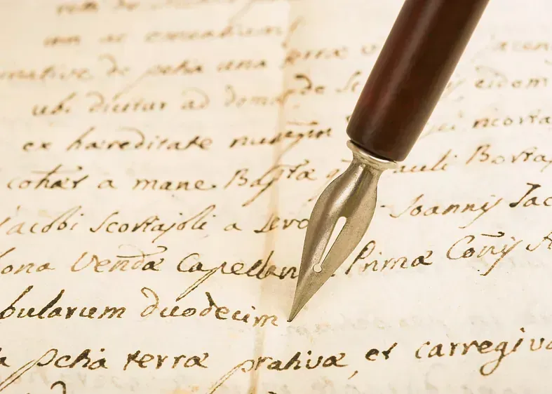 Una pluma estilográfica reposa sobre un trozo de papel escrito a mano