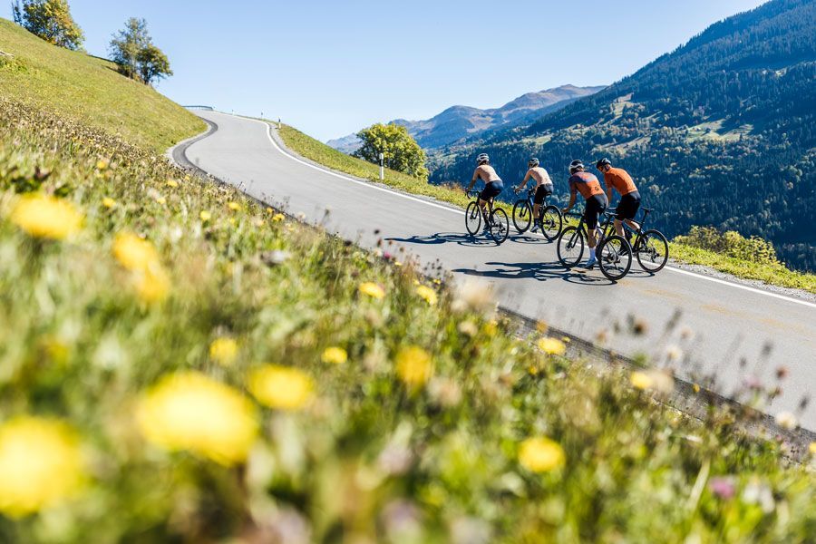 Eine Gruppe von Leuten fährt mit Fahrrädern eine Straße entlang.