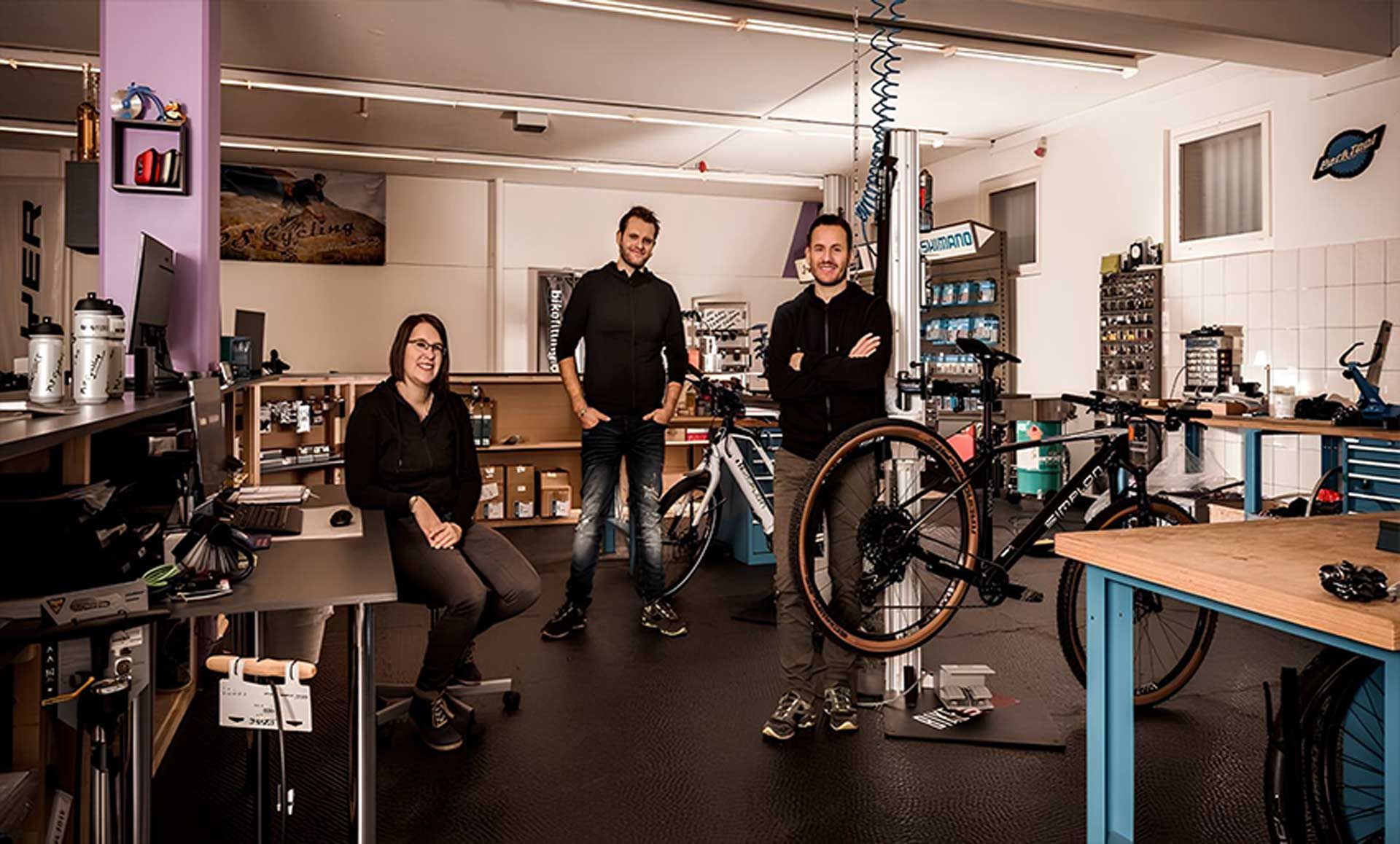 Eine Gruppe von Menschen posiert für ein Foto in einer Fahrradwerkstatt | PS Cycling AG