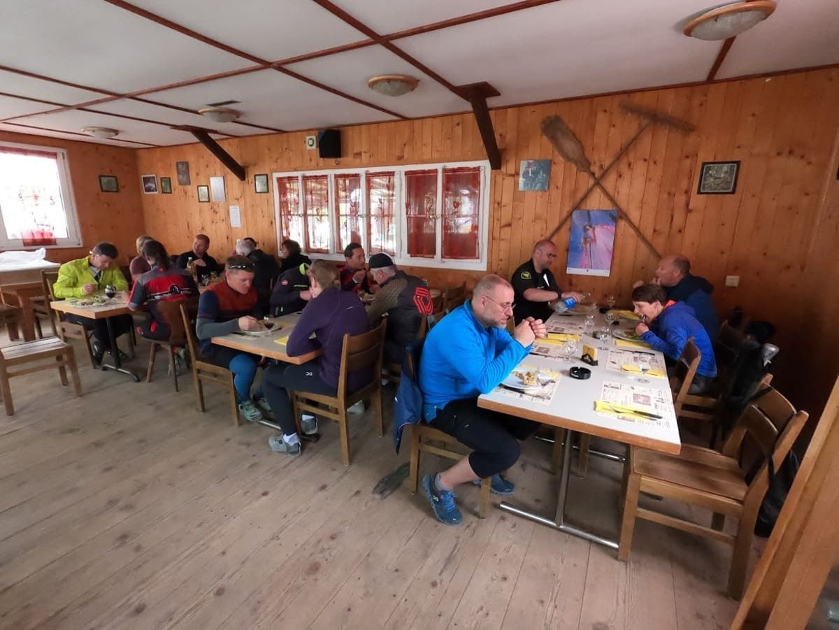 Eine Gruppe von Menschen sitzt an Tischen in einem Holzraum | PS Cycling AG