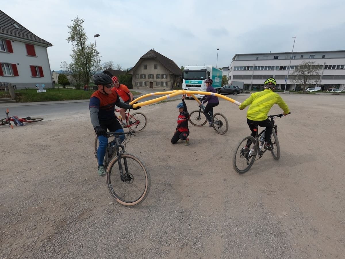 Eine Gruppe von Menschen fährt mit dem Fahrrad auf einer unbefestigten Straße | PS Cycling AG