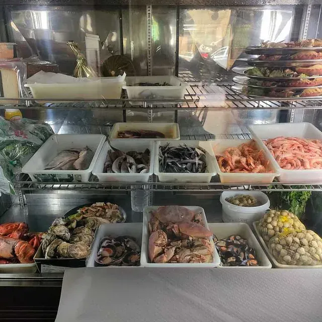 Una vitrina llena de una variedad de mariscos, incluidos camarones.