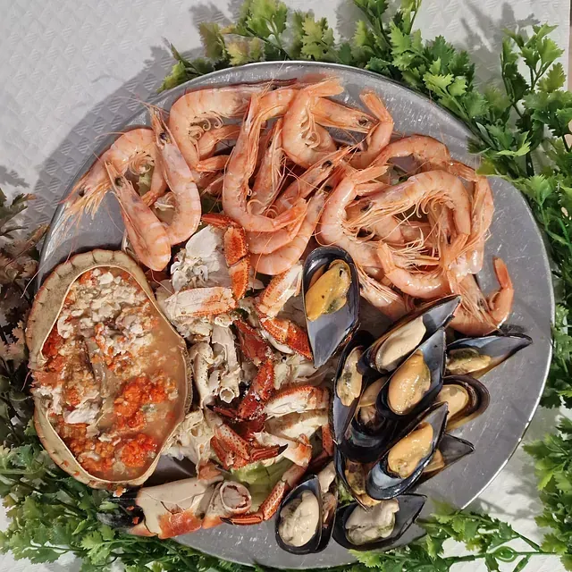 Un plato de mariscos que incluye camarones, mejillones y cangrejos.