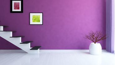 weiße Treppe in einem Raum mit lilafarbener Wand und zwei Bildern