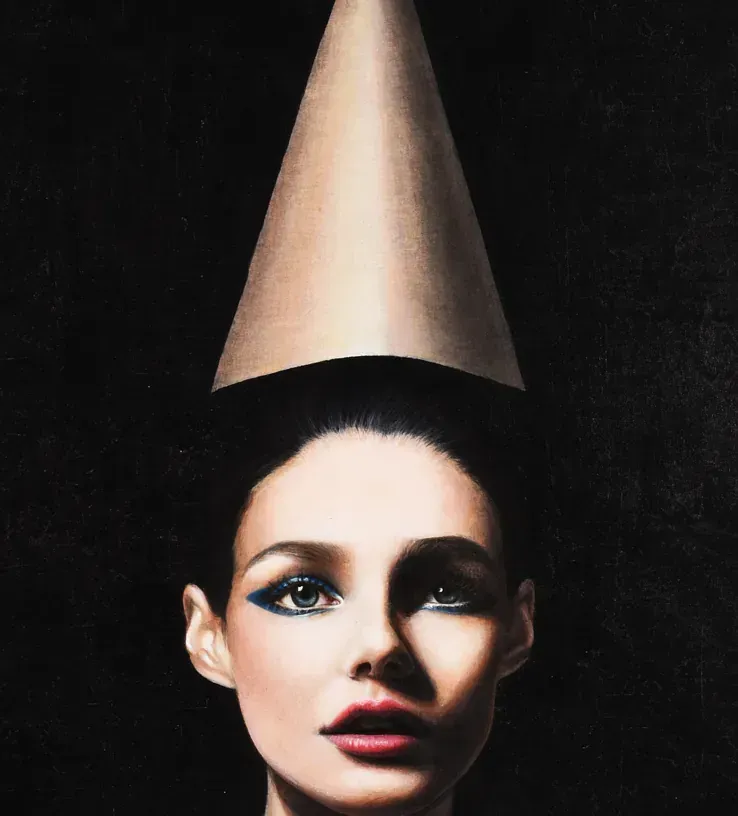 Una mujer que lleva un cono de papel en la cabeza.