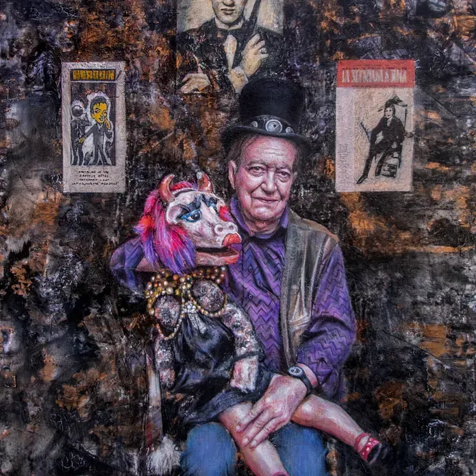 Un hombre con sombrero de copa sostiene una marioneta