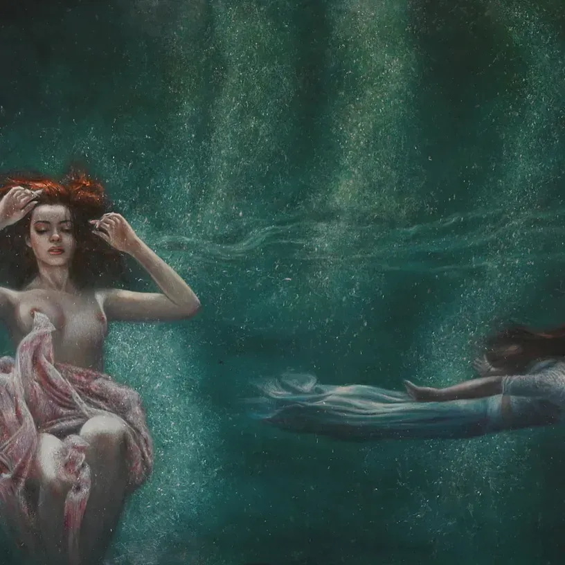 Una mujer con un vestido rosa está nadando bajo el agua junto a otra mujer con un vestido blanco.