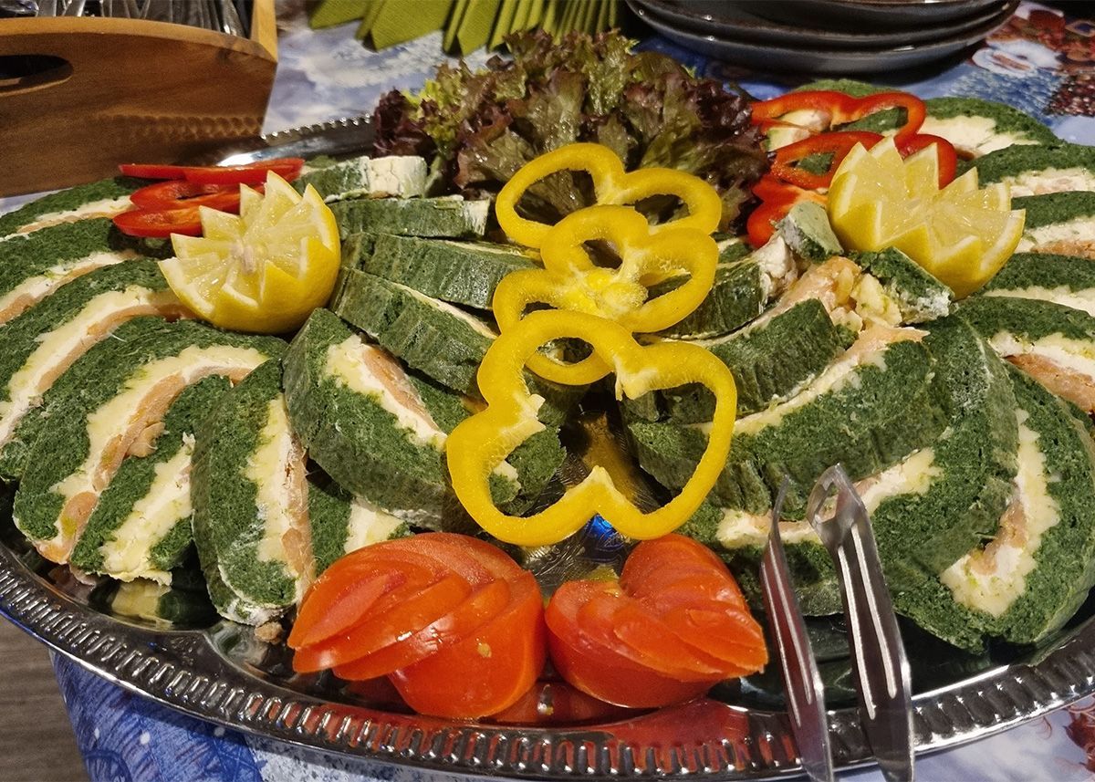 Eine bunte Platte mit geschnittenem Gemüse, dekorativ wie ein Blumenarrangement auf einem Serviertablett angerichtet.