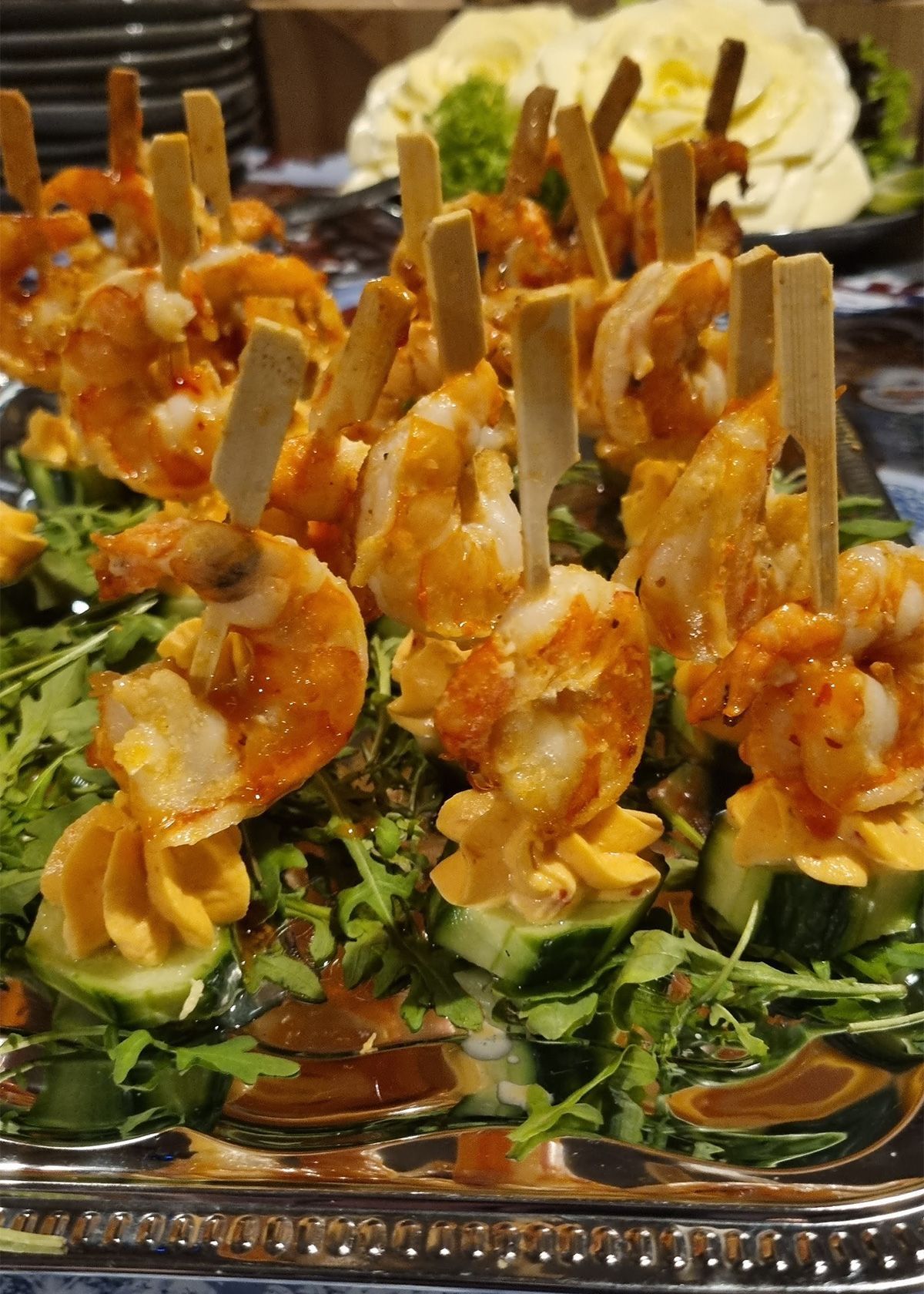 Garnelen-Vorspeisen auf Gurken- und Salatblättern, garniert mit Orangensauce, auf einem Serviertablett
