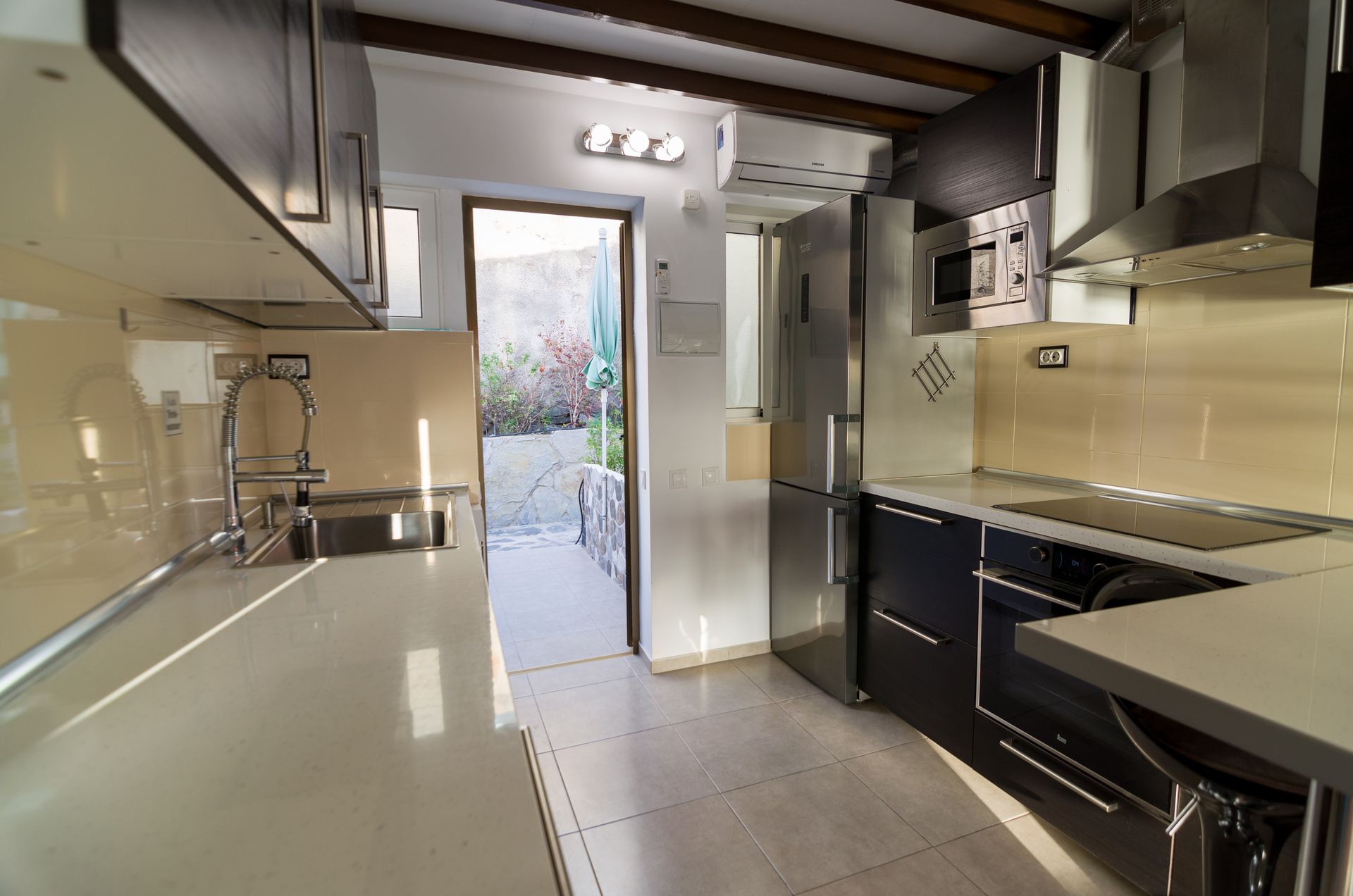 Una cocina con electrodomésticos de acero inoxidable y encimeras blancas.