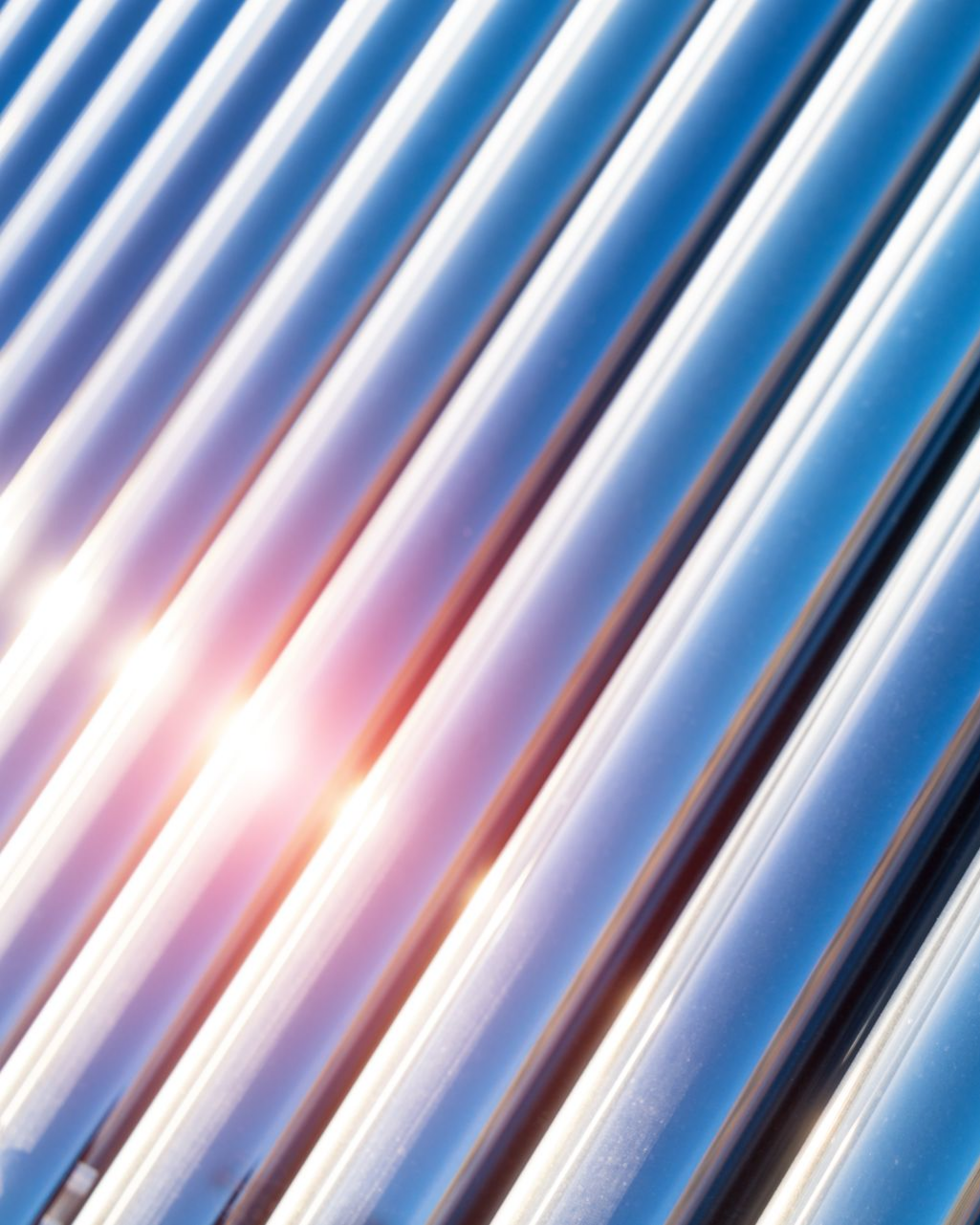 Panneaux de toiture en tôle ondulée diagonale, bleue et argentée, réfléchissant la lumière du soleil.