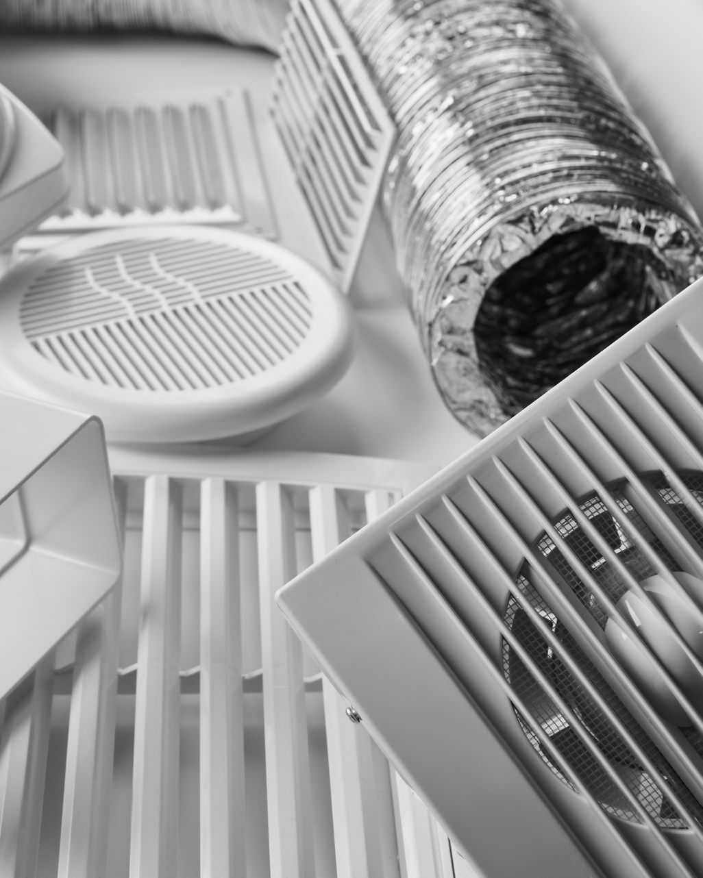 Grilles, conduits d'aération et gaines flexibles pour un système CVC, en niveaux de gris.