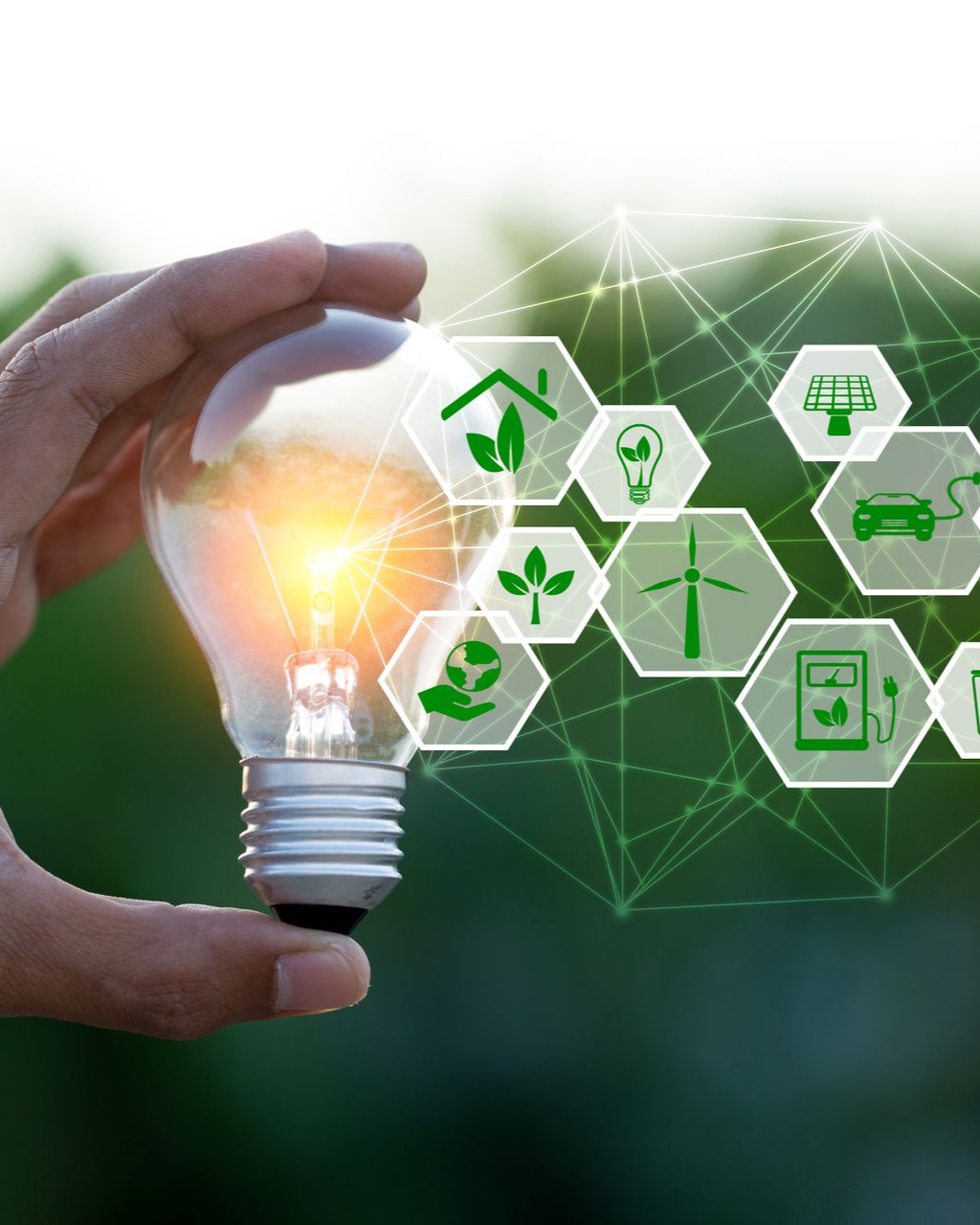 Main tenant une ampoule allumée avec des icônes d'énergie verte superposées.