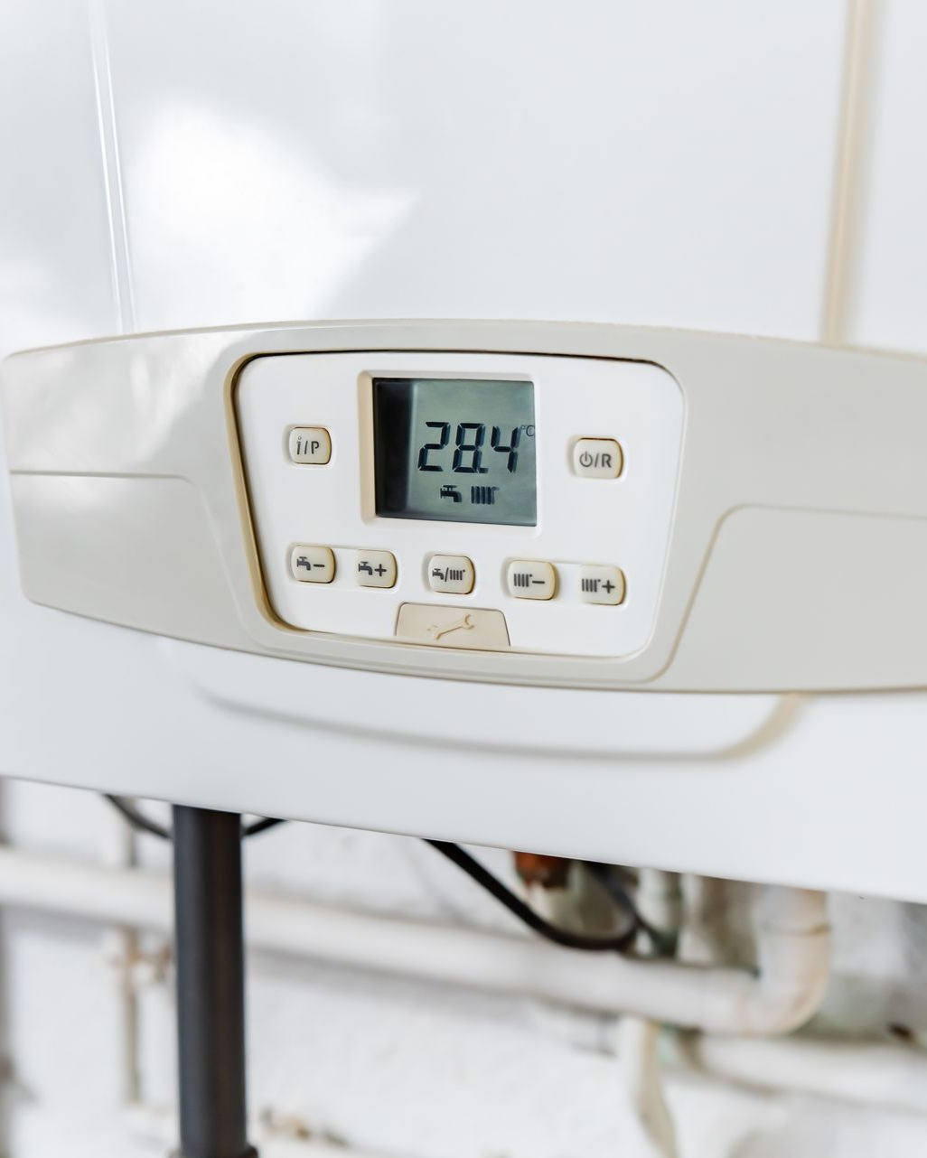 Panneau de commande de chaudière blanc avec affichage numérique indiquant 28,4 degrés.