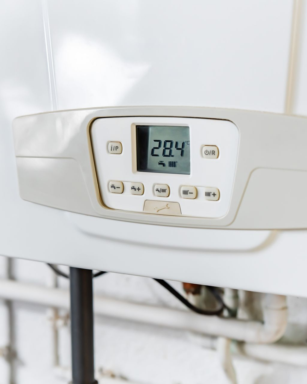 Panneau de commande de chaudière blanc avec affichage numérique indiquant 28,4 degrés.