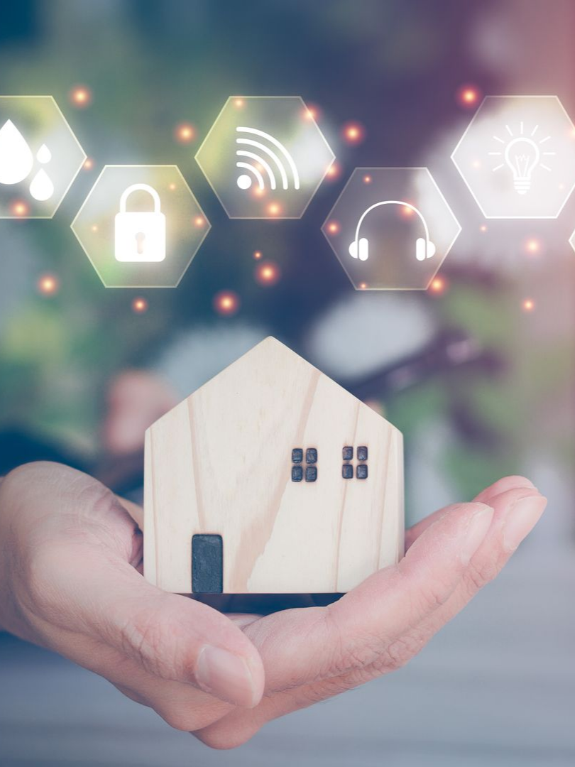 Main tenant une ampoule allumée avec des icônes d'énergie verte superposées.