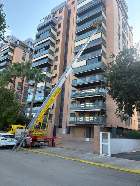 Dos hombres están trabajando en una pared de un edificio en construcción.