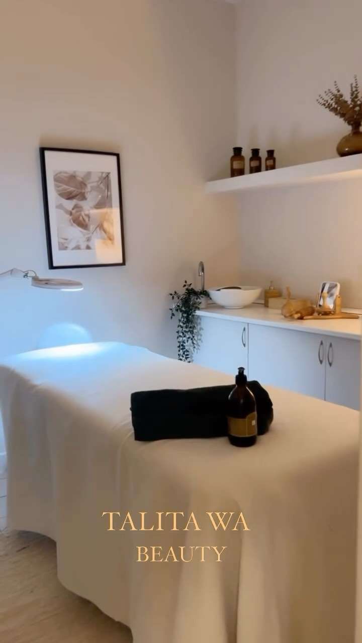 Sala de masajes con sábanas blancas, obras de arte y botellas. En la parte inferior se lee 