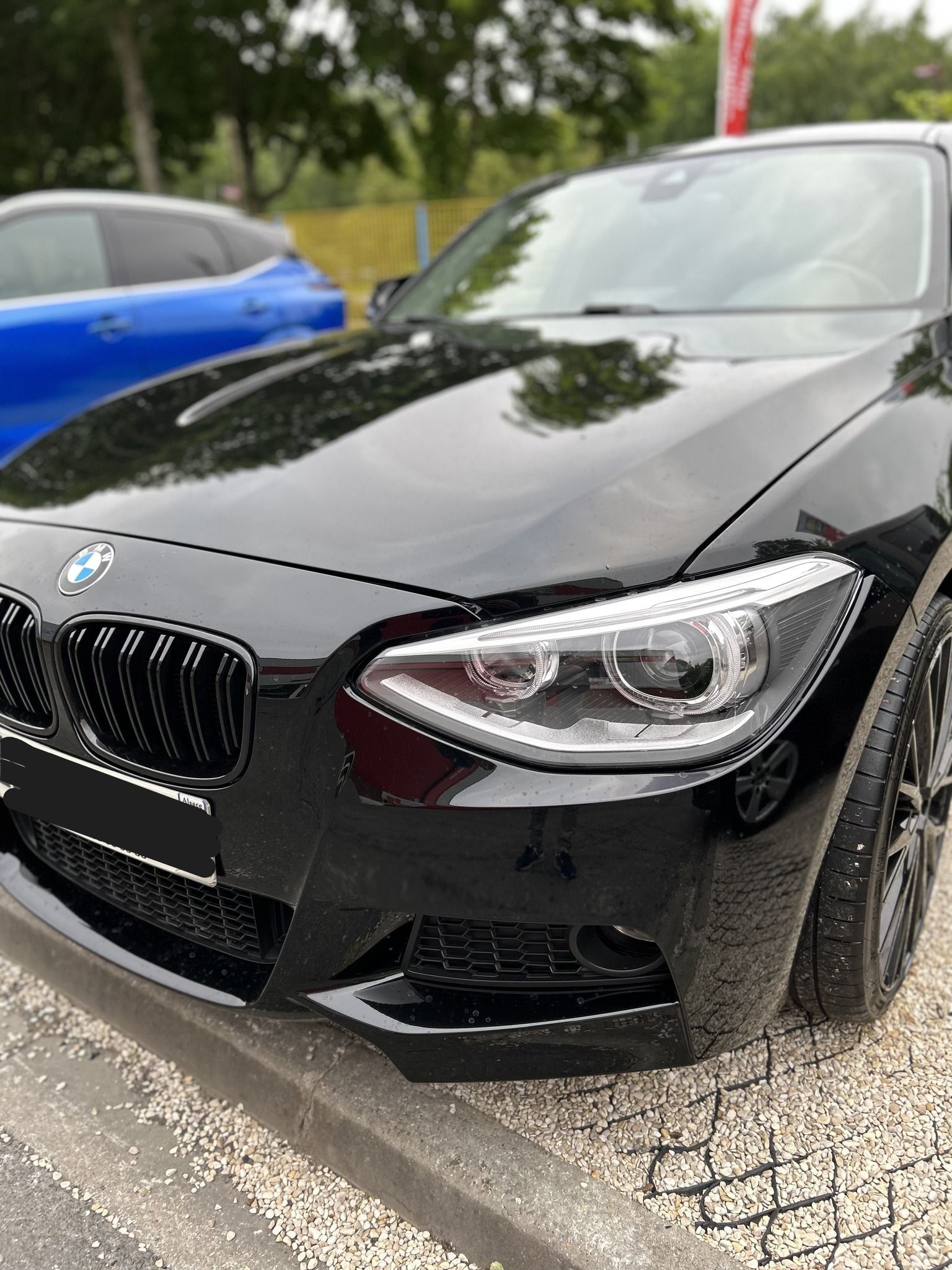 Voiture noire, vue de face, garée à l'extérieur.