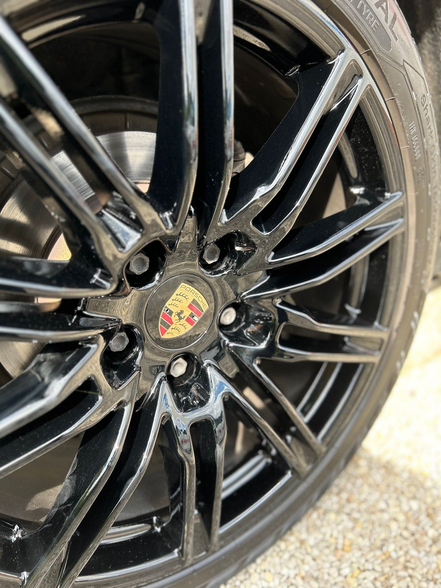 Jante de voiture noire avec le logo de la marque au centre.