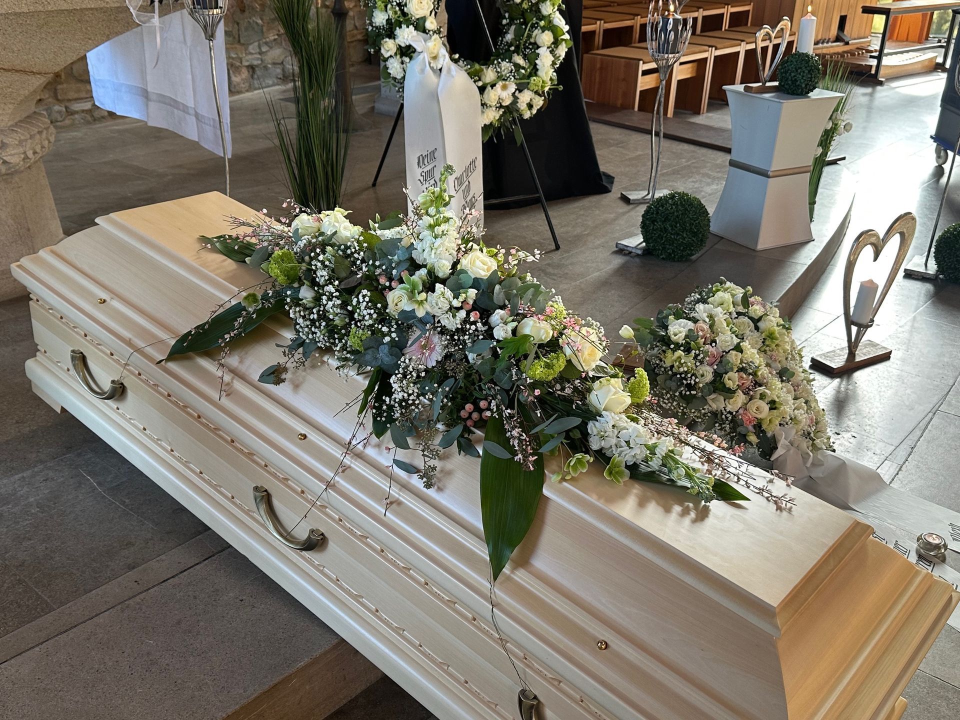 Urne inmitten von Rosen, symbolisiert den respektvollen Abschied und die Erinnerung an den Verstorbenen.