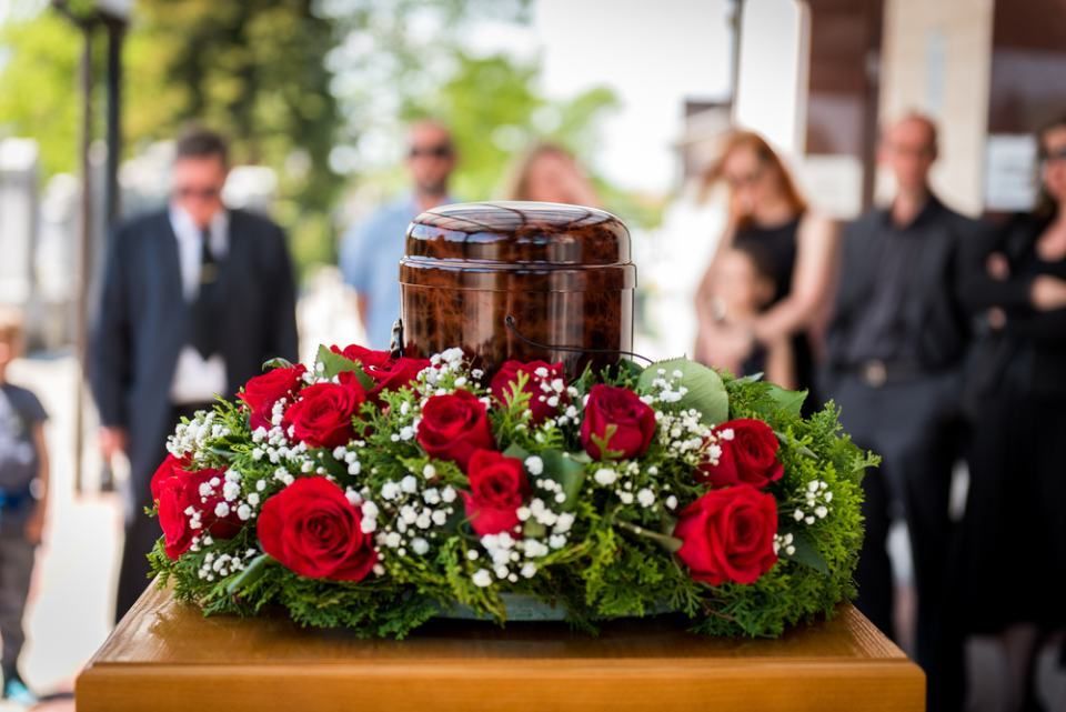 Urne inmitten von Rosen, symbolisiert den respektvollen Abschied und die Erinnerung an den Verstorbenen.