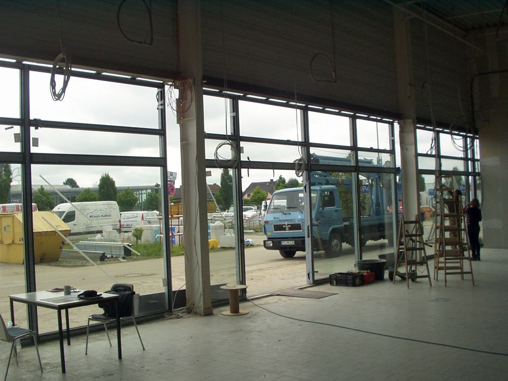 Ein blauer LKW steht vor einem im Bau befindlichen Gebäude