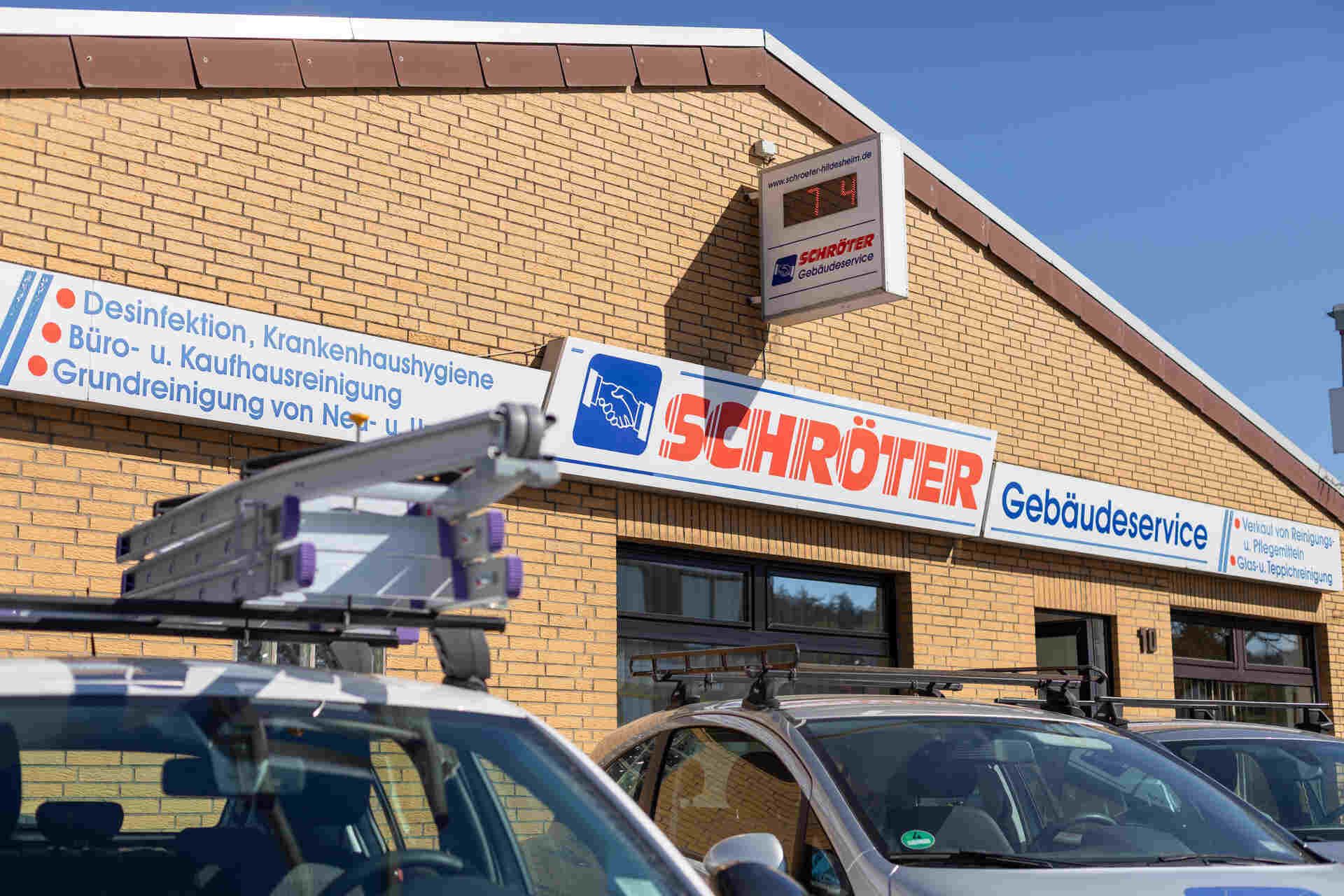 Eine Reihe vor einem Backsteingebäude geparkter Autos.