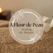 Logo for A Fleur de Peau Institut de Beauté: beige circle with white floral line art and dark brown serif text.