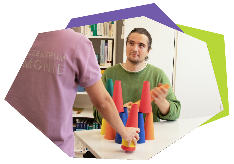 Eine Frau bringt einem kleinen Jungen den Umgang mit einem Tablet bei, Therapiezentrum Harmonie