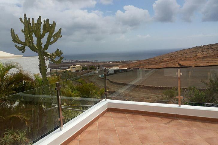 Un balcón con vista al mar y a las montañas.