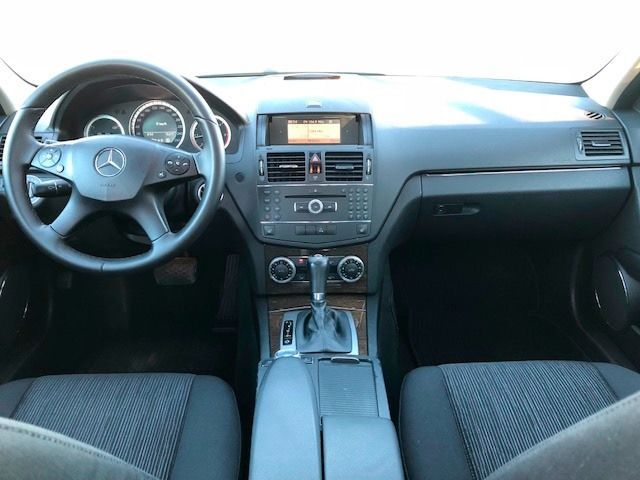 El interior de un automóvil Mercedes Benz con volante y tablero de instrumentos.