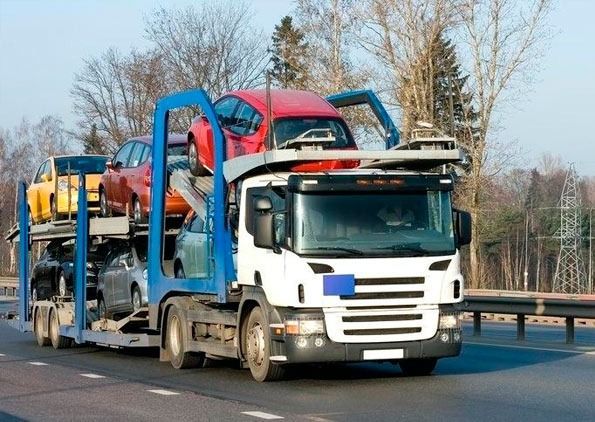 Un camión transportando automóviles circula por una autopista transportando automóviles.