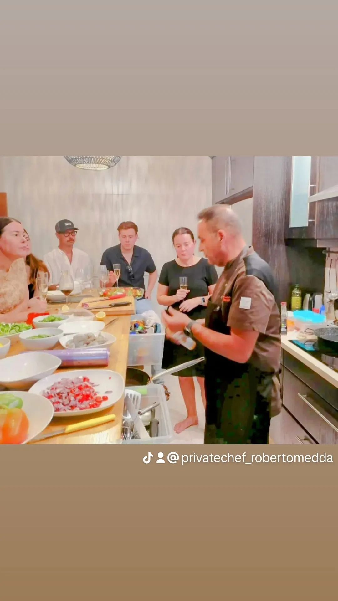 Un hombre está enseñando a un grupo de personas cómo cocinar en una cocina.