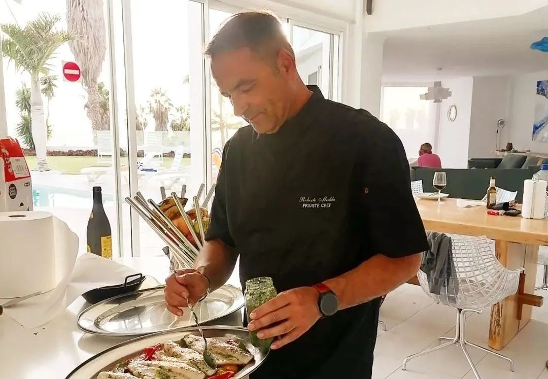 Un hombre está parado frente a un plato de comida.