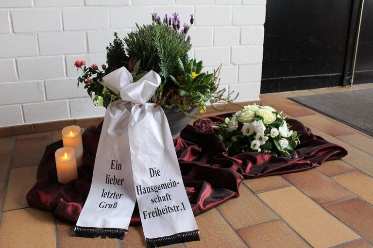 Urne mit Blumenkranz
