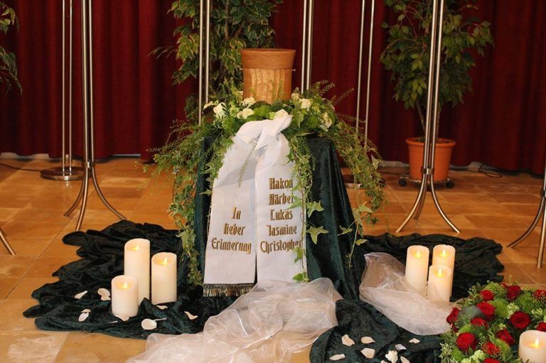 Urne mit Blumenkranz