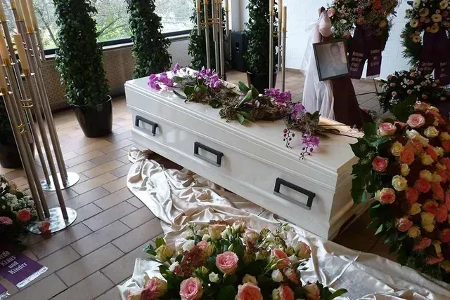 Bilder von Sarg mit Blumenkränzen und Deko
