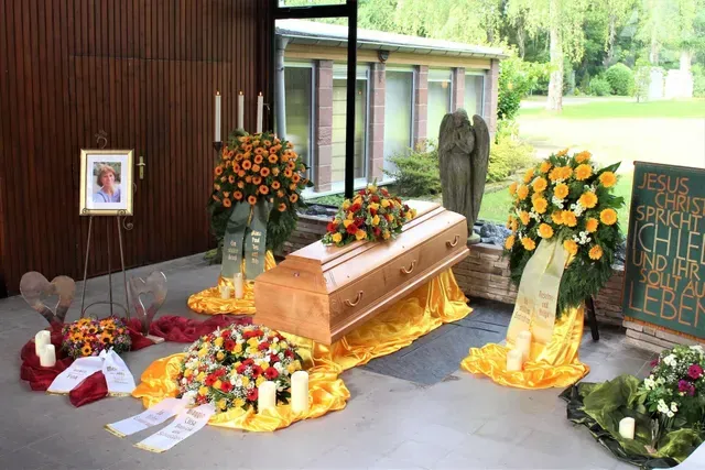 Bilder von Sarg mit Blumenkränzen und Deko