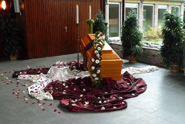 Bilder von Sarg mit Blumenkränzen und Deko