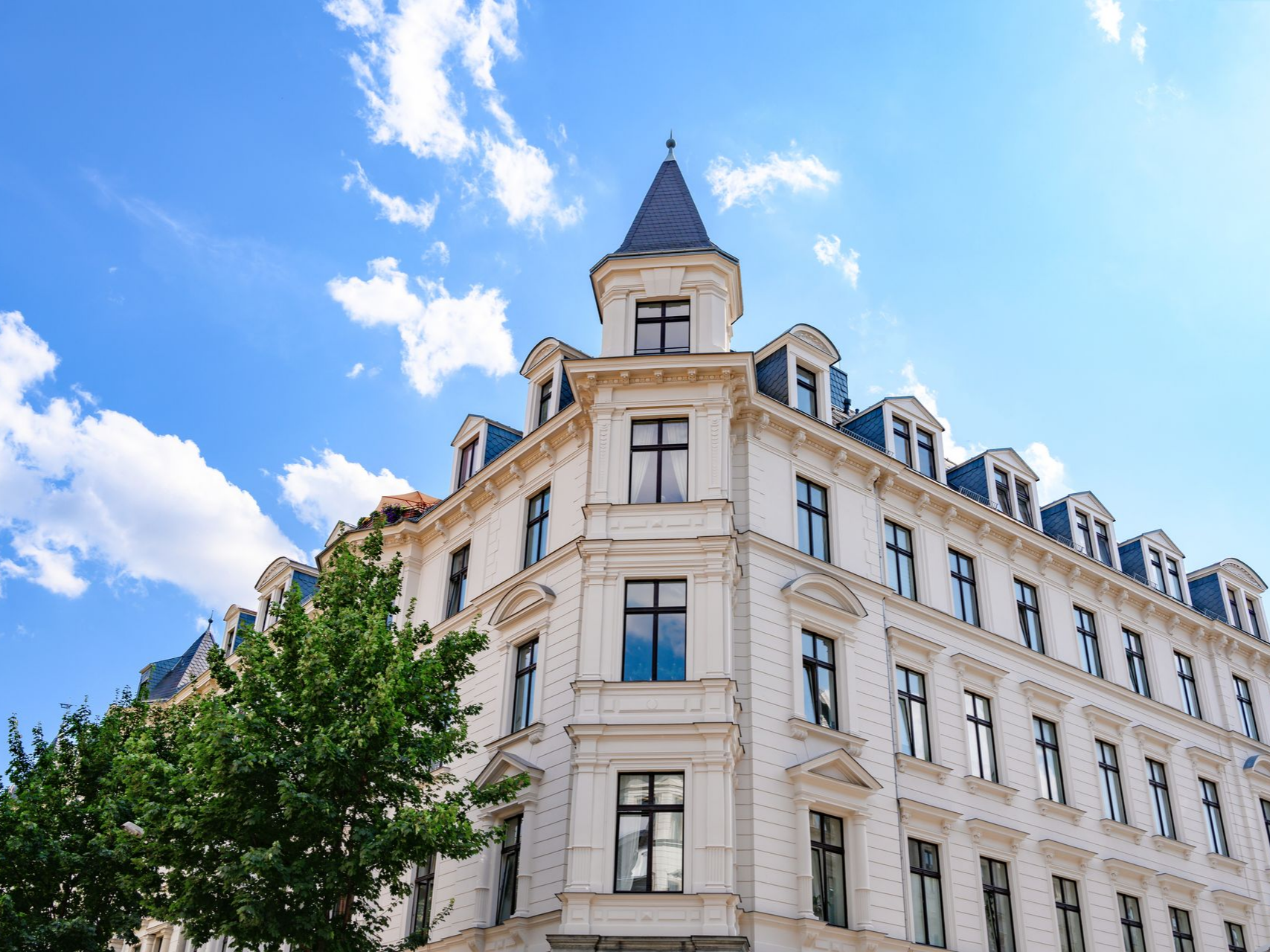 Bâtiment d'angle blanc avec des fenêtres.