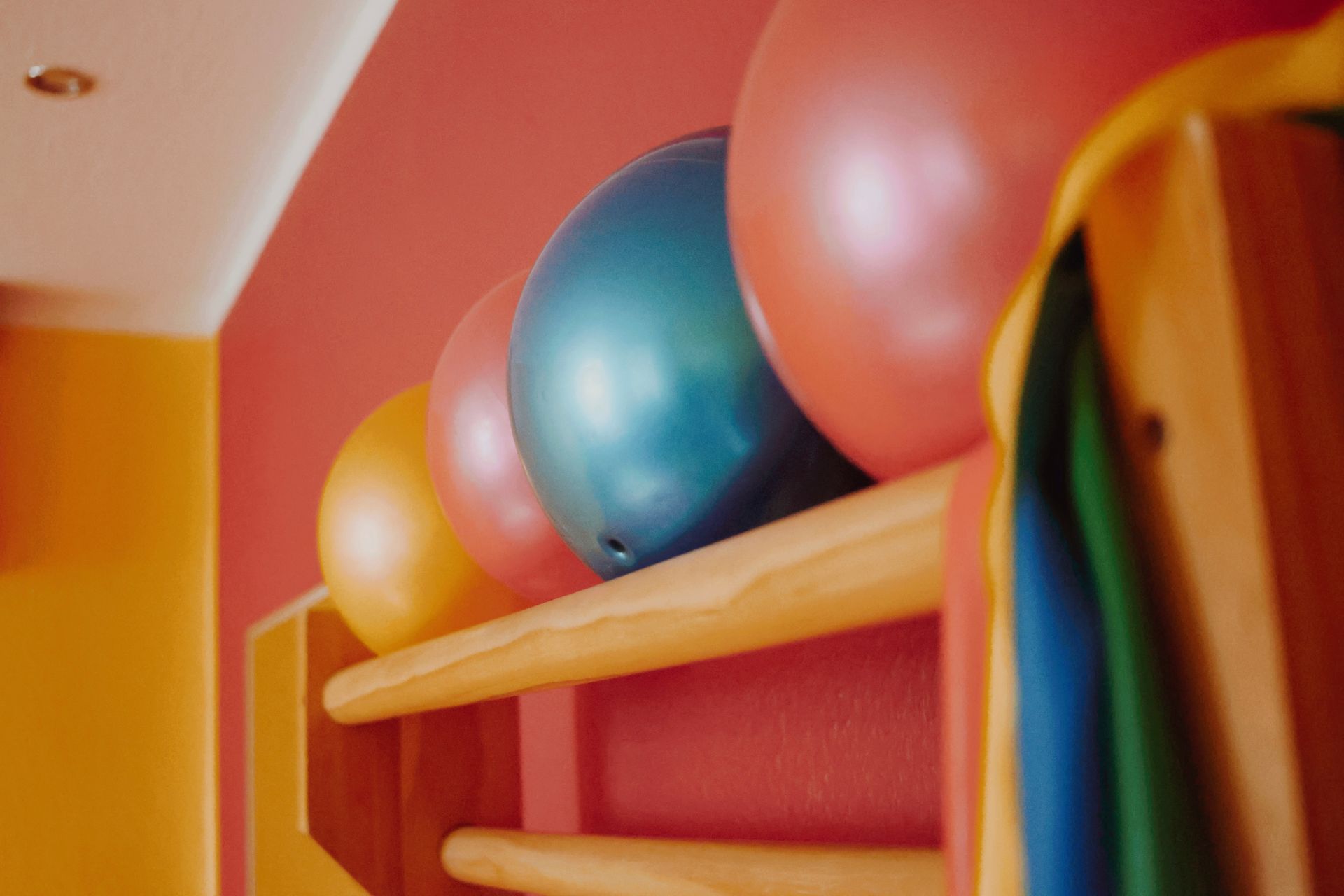 Ein Haufen Bälle liegen auf einem Holzregal